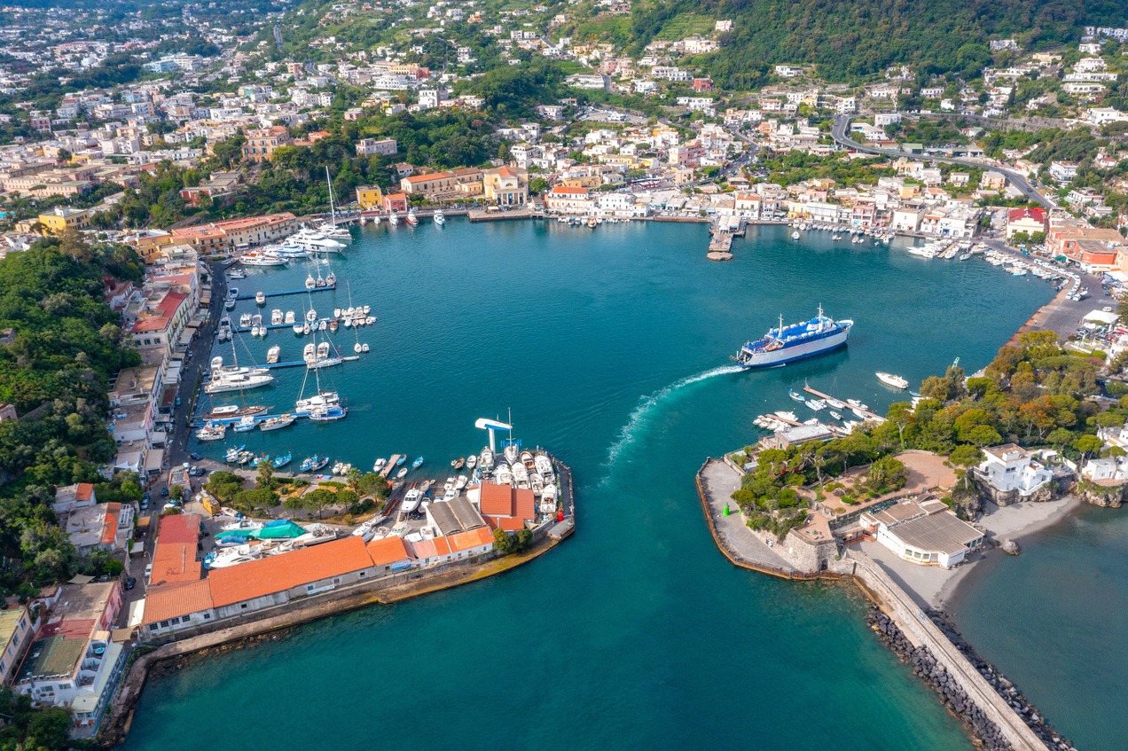 Aerial view of the round harbour basin of Ischia Porto, with a ferry entering